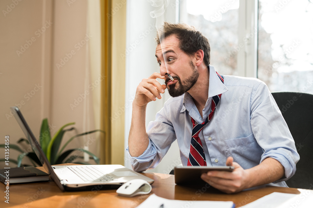 Stressed businessman working in his office Stressed businessman working in his office