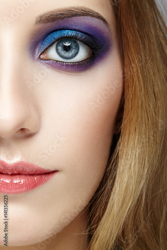 Female half face with  and violet and blue eyes makeup