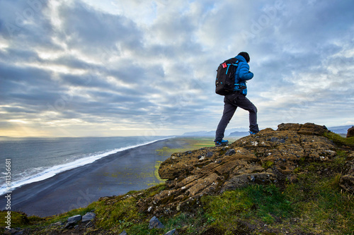 A man walking on top of Dyrholaey, Iceland