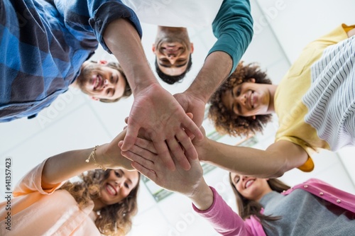 Team of smiling executives forming hand stack photo