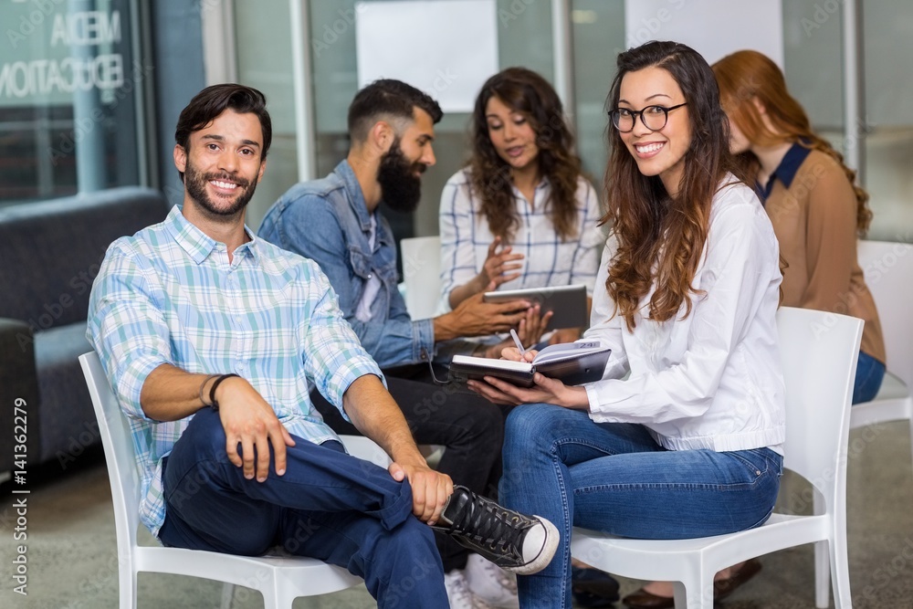 Portrait of male and female executives sitting in meeting Portrait of male and female executives sitting in meeting
