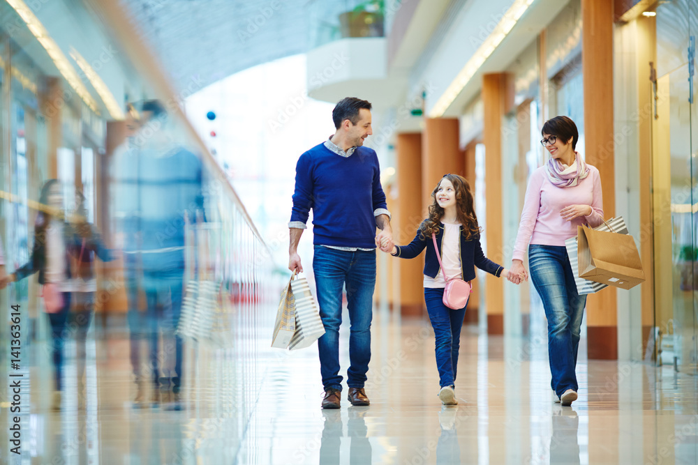 Family of three spending weekend in shopping center