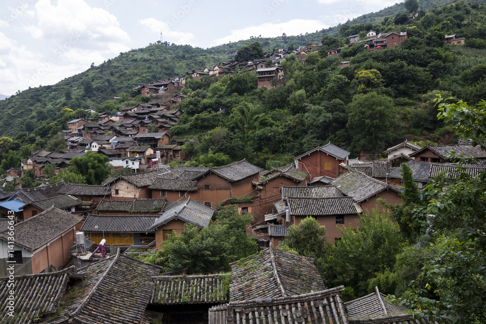 Traditional Chinese village in Yunnan province descending from a hillside