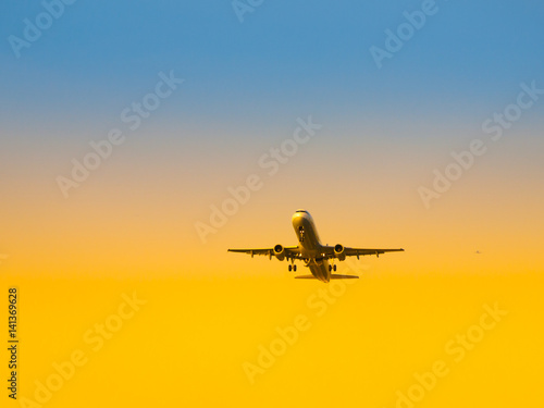 Aircraft take-off from airport at sunset time. Air transportation and leaving on holiday theme.