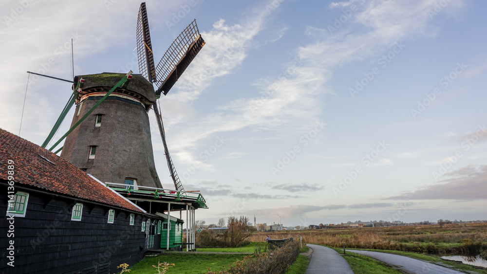 Naklejka premium Windmills in landscape view with smooth river surface