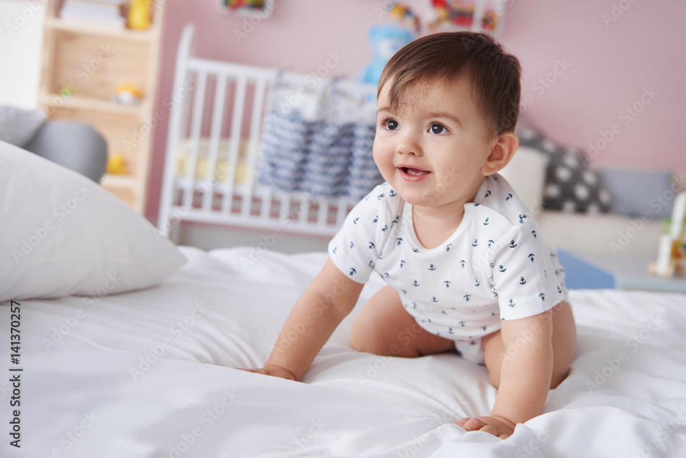 Smiling baby boy crawling on the bed Smiling baby boy crawling on the bed
