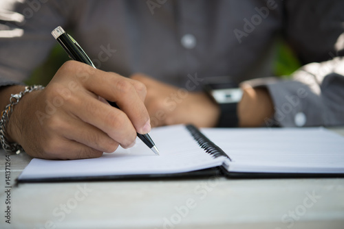 Man hand writing on notebook.