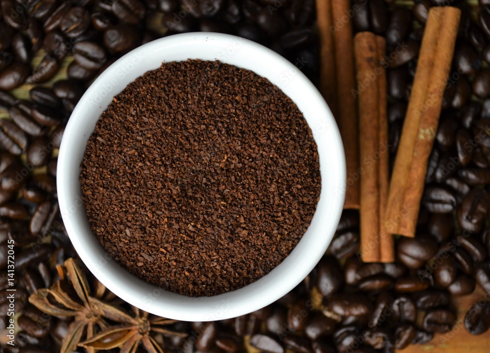 Coffee grounds with coffee beans and cinnamon sticks Coffee grounds with coffee beans and cinnamon sticks