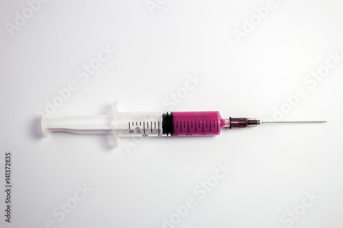 Medical syringe with pink liquid isolated