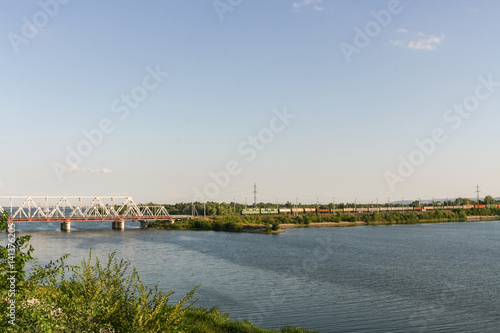 Railway bridge through the river Volga and freight train is movi