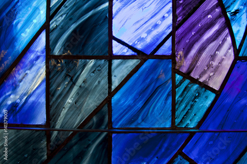 Beautiful shades of deep blue and purple on uniquely shaped stained glass window.
