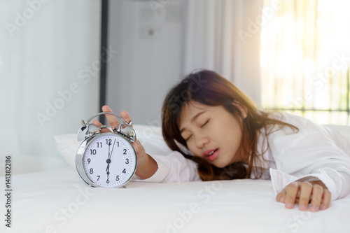 Canvastavla Sleepy woman trying turn off alarm clock in the morning.