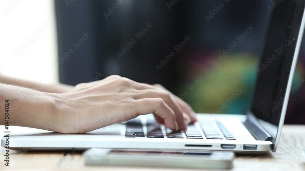 Close-up of a young woman typing on a laptop keyboard Close-up of a young woman typing on a laptop keyboard