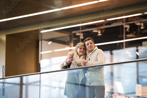 Photography Senior couple standing at the train station, waiting, hugging