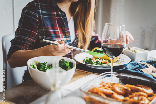 Young hipster girl enjoying healthy homemade food  happy friends celebrating anniversary at home  toasting and traditinal concept