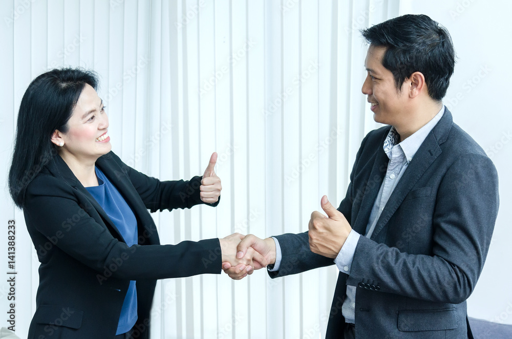 Asian woman and man handshake and showing thumbs up. Asian woman and man handshake and showing thumbs up.