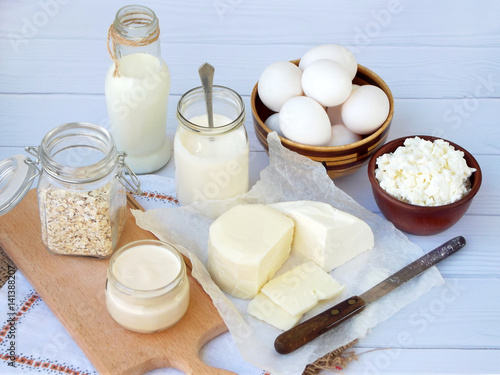 Set of fresh dairy products on wooden background: milk, cheese, cottage, yogurt, egg, mozzarella, ryazhenka, feta.