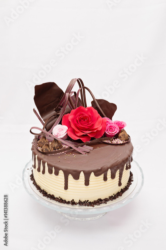 Rould  one layer white and brown chocolate cake with red and pink edible marzipan flowers on top