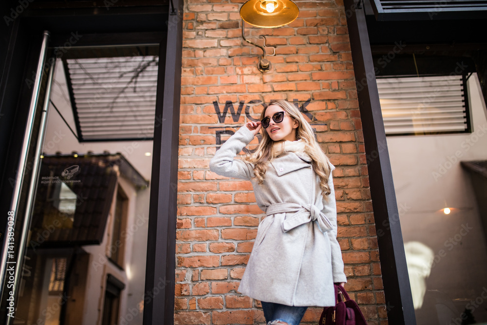 Obraz premium Beautiful young woman walking on the street near work place building