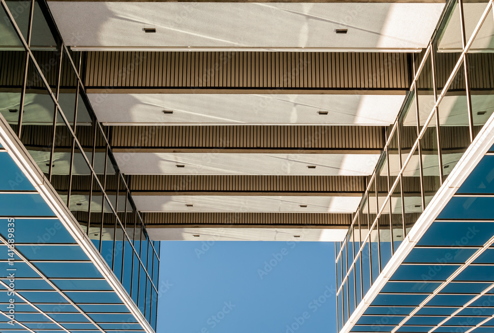 Obraz premium Urban Geometry, looking up to glass building. Modern architecture, glass and steel. . Abstract architectural design. Inspirational, artistic image.Minimal art. Architectural design. Building exterior.