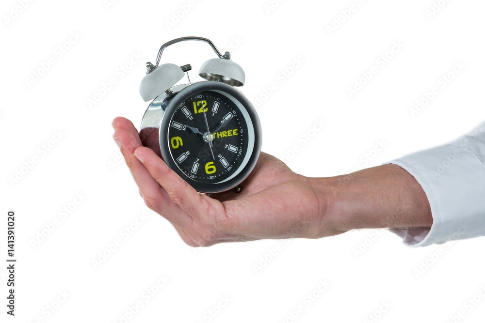 Hand of executive holding alarm clock Hand of executive holding alarm clock