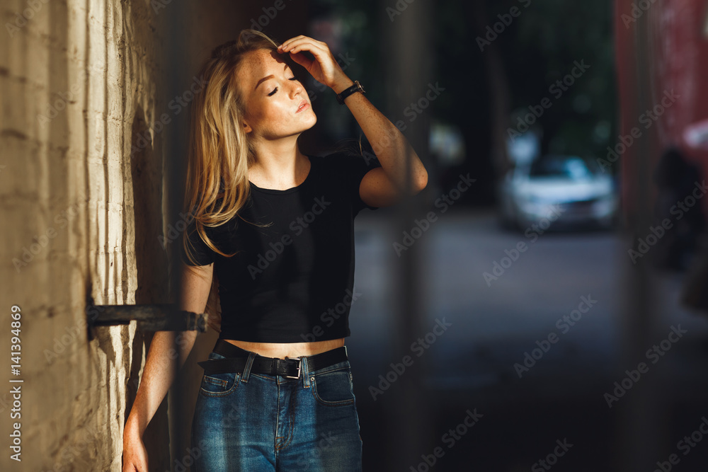 Fototapeta premium Street style. Beautiful woman walks on the street at the Moscow City at sunny spring day.