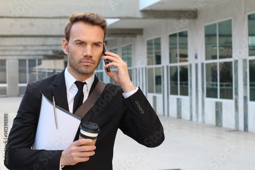 Focused businessman walking during phone call outdoors 