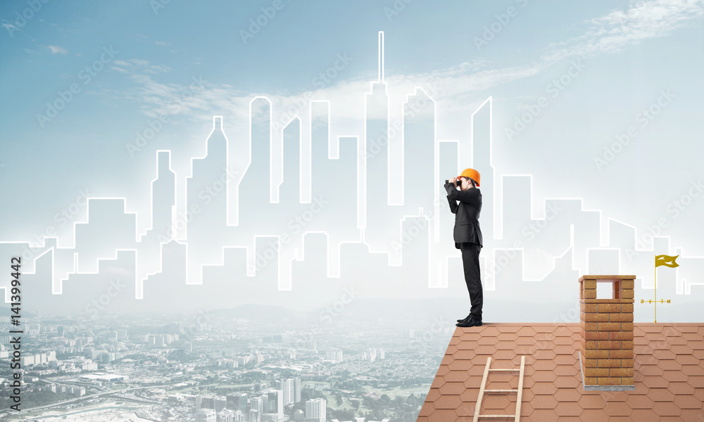 Engineer man standing on roof and looking in binoculars. Mixed media Engineer man standing on roof and looking in binoculars. Mixed media
