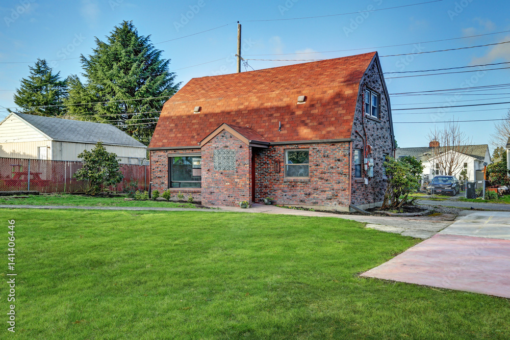 Obraz premium Small red brick home on a sunny day