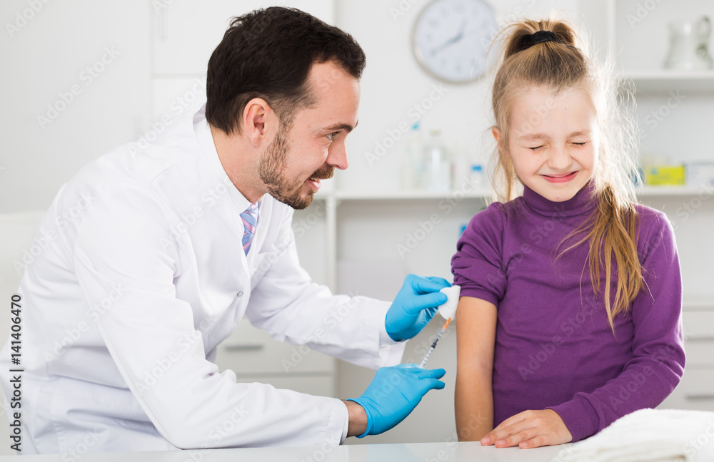 Obraz premium Male doctor injecting little patient