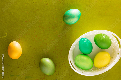 Painted Easter eggs basket on the old wooden background photo