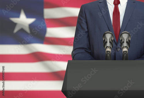 Obraz na plátně Businessman or politician making speech from behind a pulpit with national flag