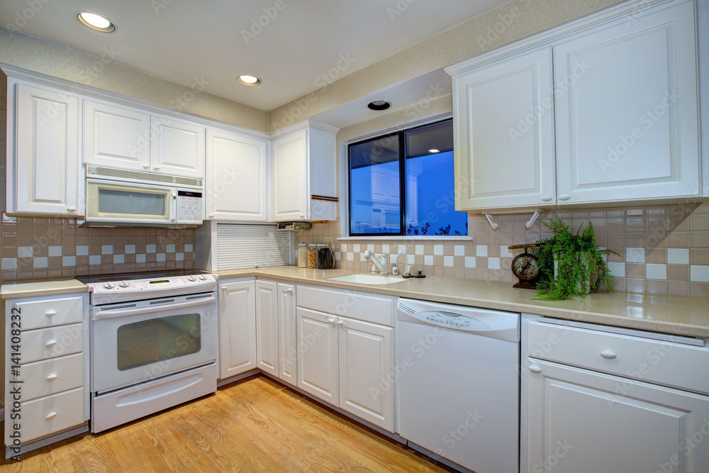 White kitchen design with hardwood floor and white appliances White kitchen design with hardwood floor and white appliances