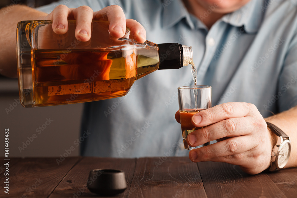 businessman celebrating by pouring more drink to himself businessman celebrating by pouring more drink to himself
