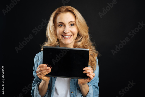 Pretty smiling woman advertising black tablet
