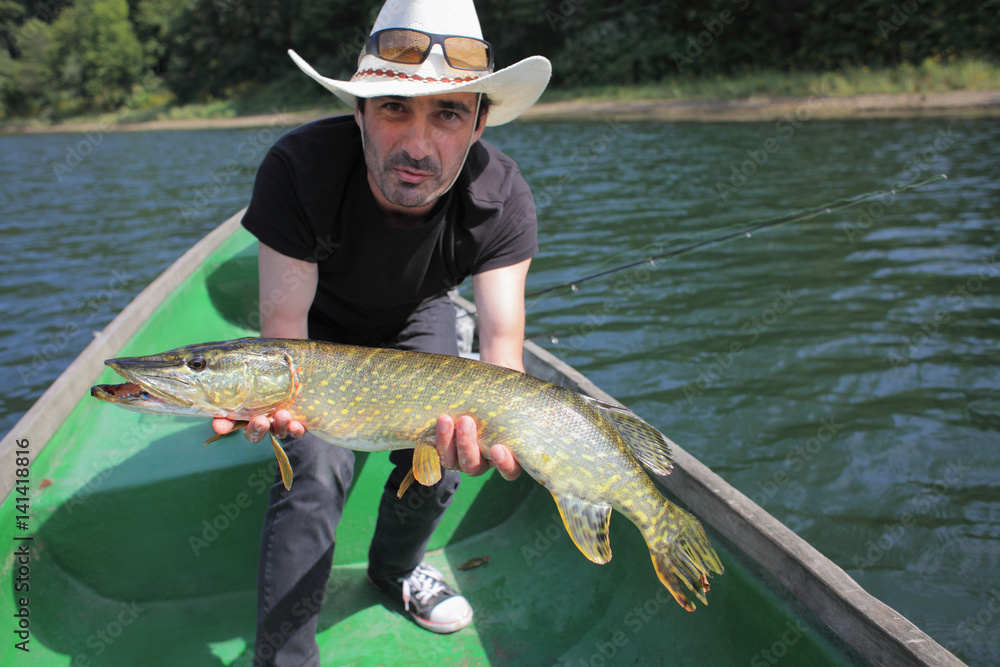 Happy fisherman presenting big pike caught during spin fishing competition. Happy fisherman presenting big pike caught during spin fishing competition.
