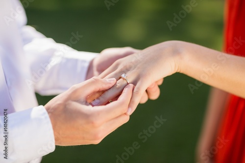 Man putting a ring on womans finger in the restaurant