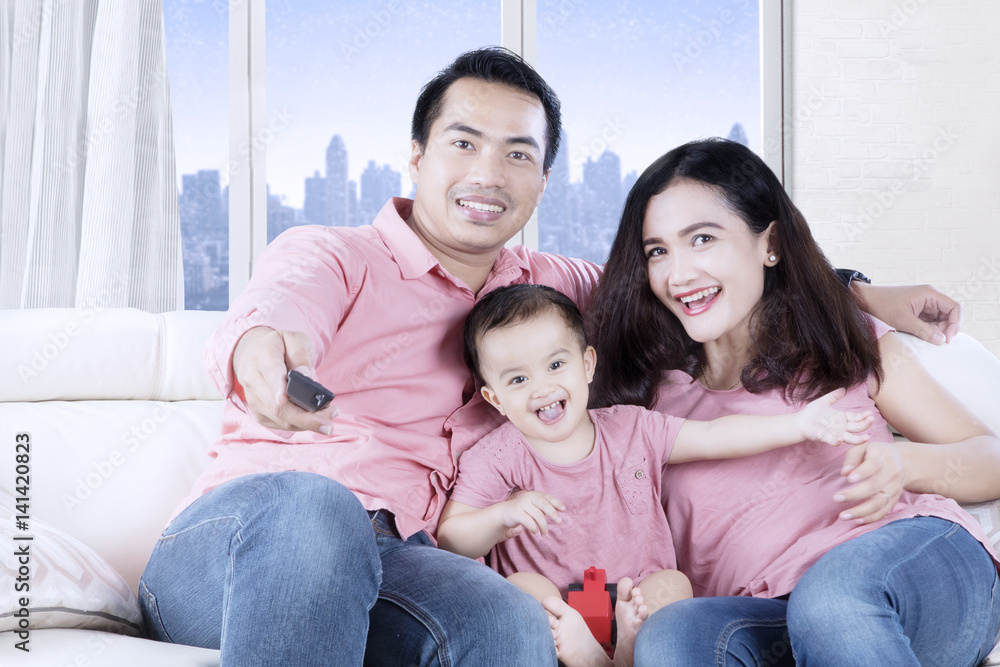 Asian family watching television in the apartment Asian family watching television in the apartment