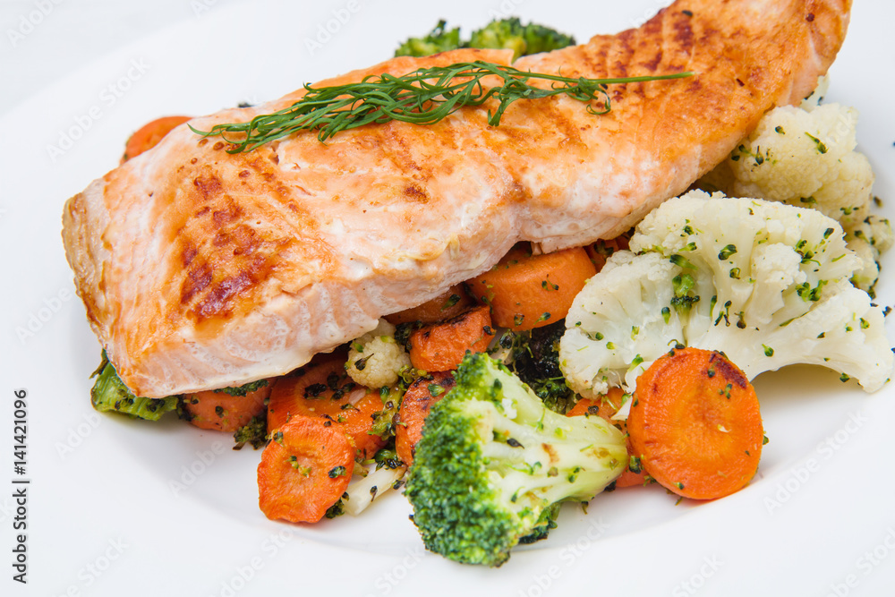 salmon fillet on a bed of broccoli, cauliflower and carrots salmon fillet on a bed of broccoli, cauliflower and carrots