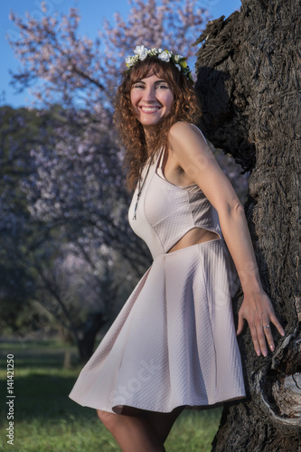 beautiful woman next to a almond tree