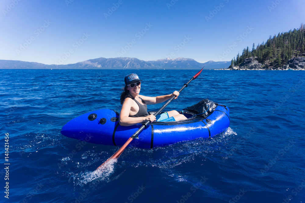Naklejka premium Young woman in hat and sunglasses enjoys watersports on a summer day at Lake Tahoe, California