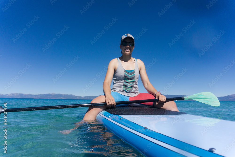 Young woman in hat and sunglasses enjoys watersports on a summer day at Lake Tahoe, California