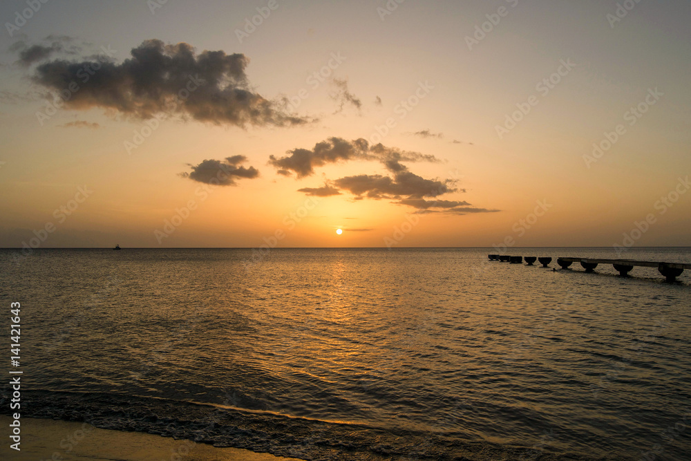 Dominica Island Sunset with pier and clouds in distance 
