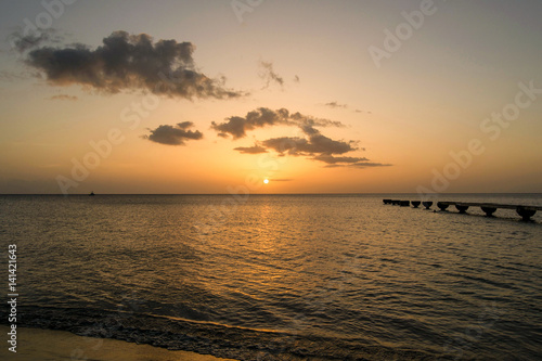 Dominica Island Sunset with pier and clouds in distance 