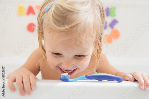 Smiling girl with toothbrush in bathroom