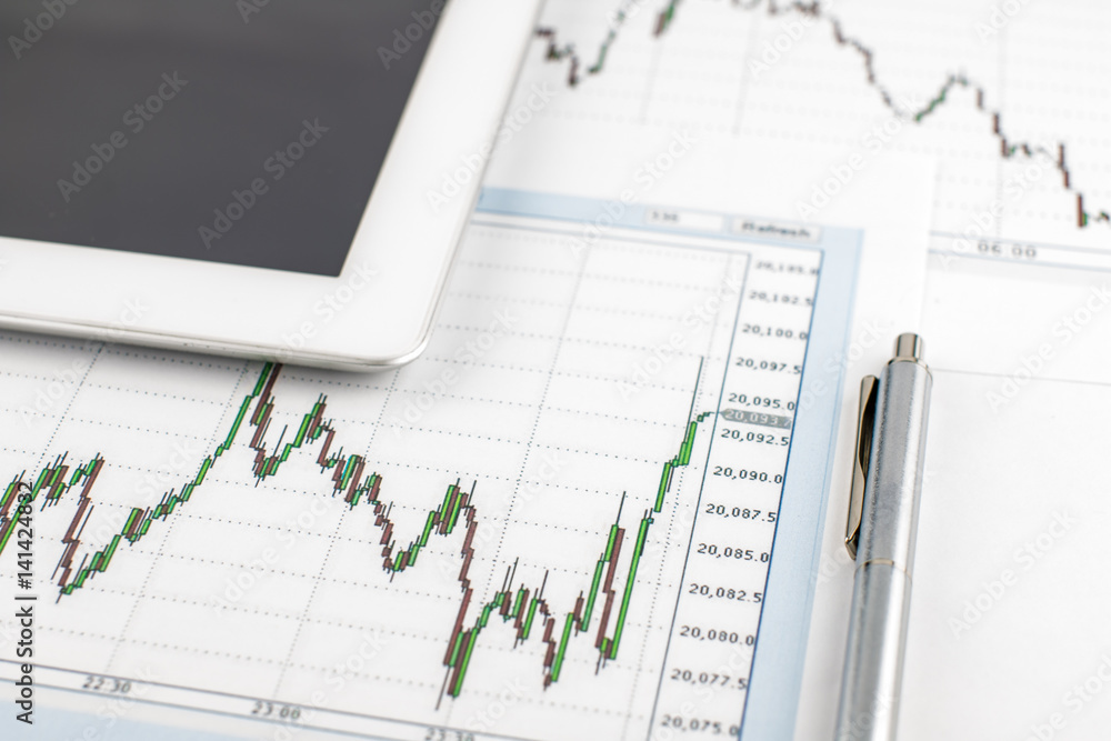 Tablet computer, the Dow Jones chart and pen on a white background, business concept. Tablet computer, the Dow Jones chart and pen on a white background, business concept.