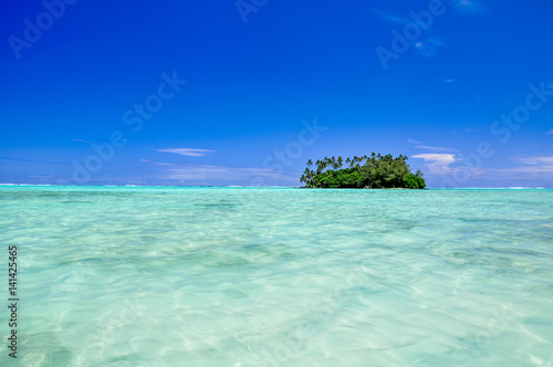 Stunning view of Motu Taakoka, a small island in the lagoon of Rarotonga near Muri Beach. Cook Islands in the South Pacific Ocean, Clear, shallow, water, small island with palm trees, copy space. 