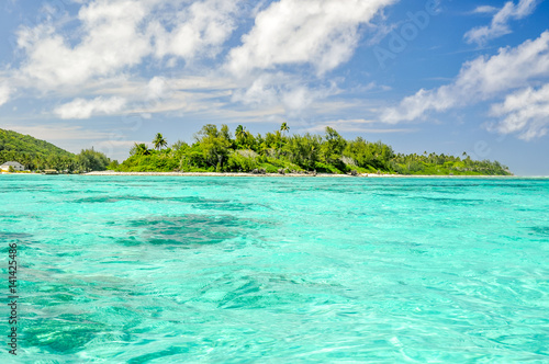 Stunning view of Motu Koromiri, a small island in the lagoon of Rarotonga near Muri Beach. Cook Islands in the South Pacific Ocean, Clear, shallow, water, small island with palm trees, copy space. 