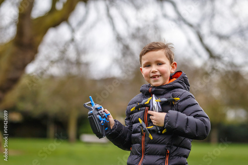 School boy with quadrocopter inthe park photo