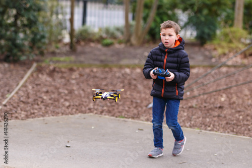 School boy with quadrocopter inthe park photo